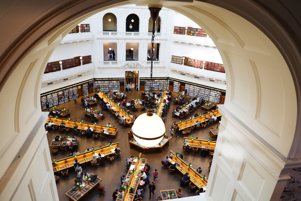 services-img High-angle shot of a crowded dome library room with study tables and shelves.
