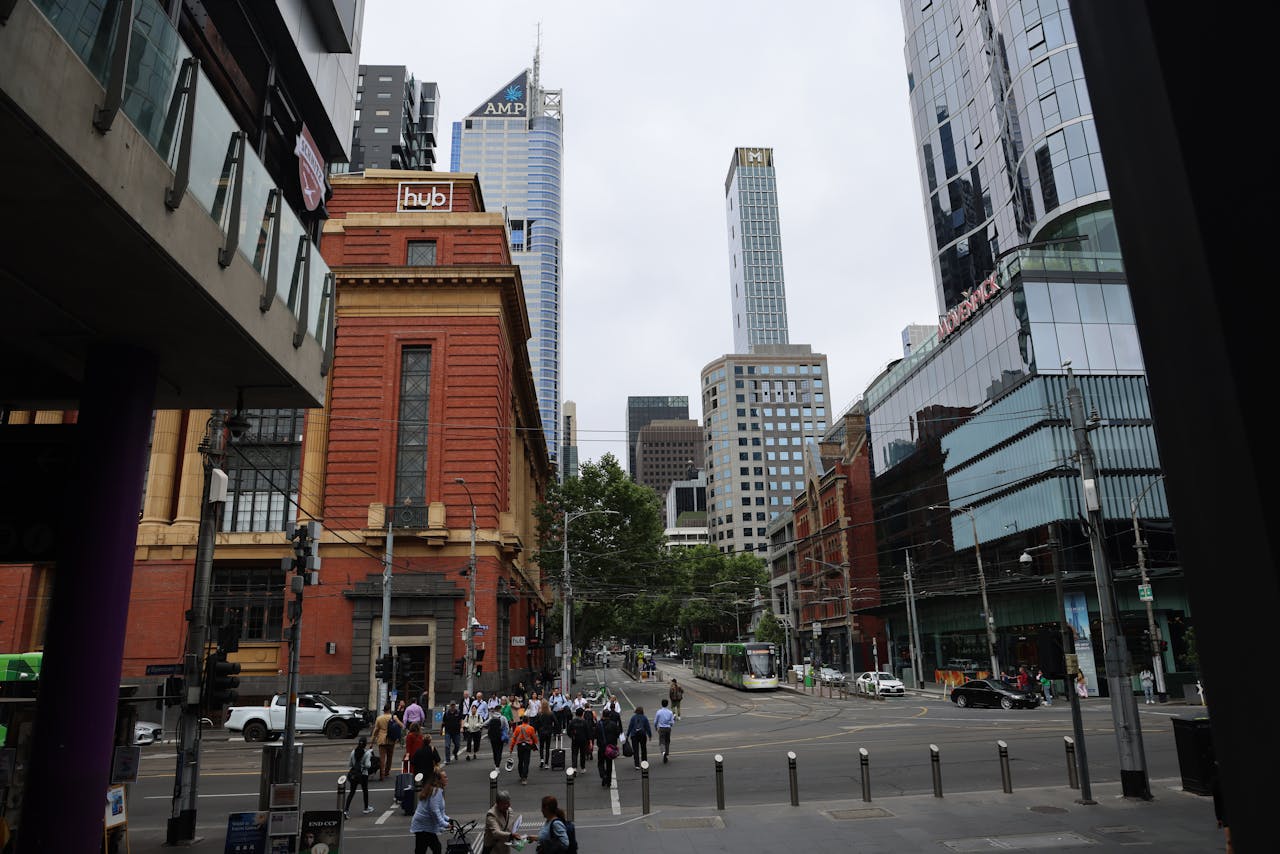 about-01 Urban intersection in Melbourne with skyscrapers and pedestrians.